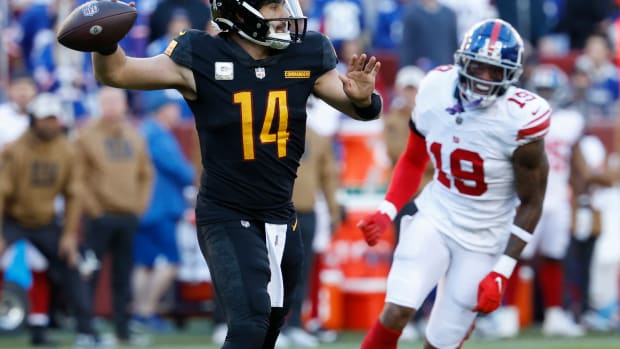 Washington Commanders quarterback Sam Howell (14) passes the ball as New York Giants wide receiver Isaiah Hodgins (18) chases during the fourth quarter at FedExField.
